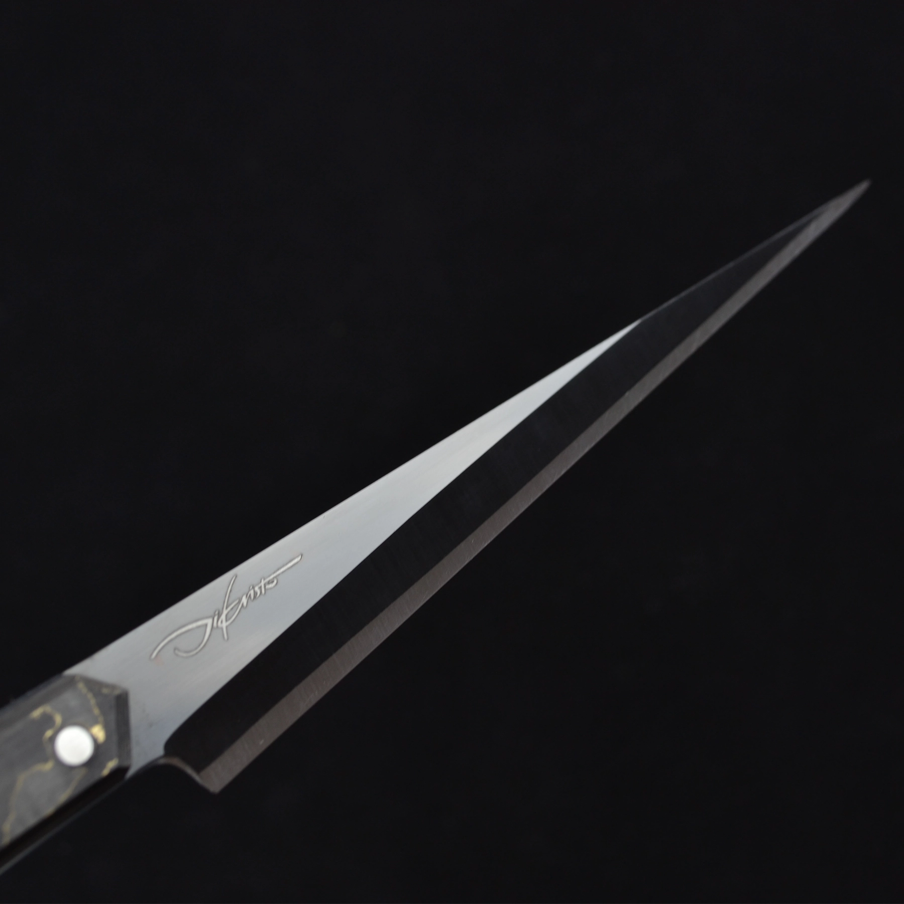 Close-up of the Tyndareus stainless steel knife blade with black coating, emphasizing its superfine stainless steel material and sharp edge.