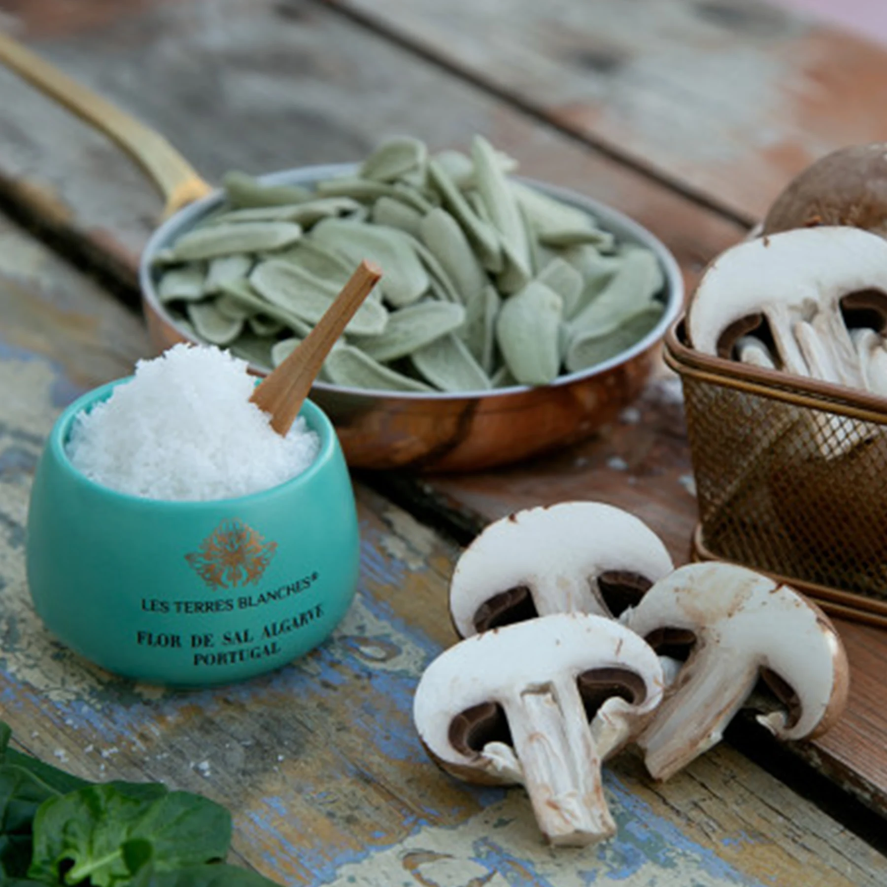 Elegant ceramic jar of organic salt beside fresh herbs