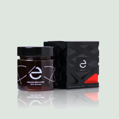 Jar of Greek Premium Raw Honey, Arbutus Wild Strawberry Honey, from Eulogia of Sparta with a rich golden color and unique label design.