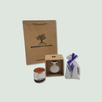 A set of gourmet items including a brown paper gift bag, a jar of marjoram seasoning, a bottle of olive oil in a box, and a fabric bag of lavender. The gift bag has a rope handle and the logo "gourmet.wearedoubledot.com" printed on it.