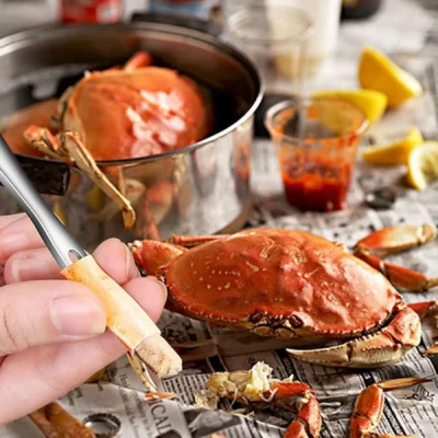 Hand using lobster fork to pick meat from crab legs