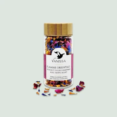 A front view of the Flamme Orientale edible flowers bottle, showcasing vibrant rose, tagetes, and blueberry petals inside a glass jar