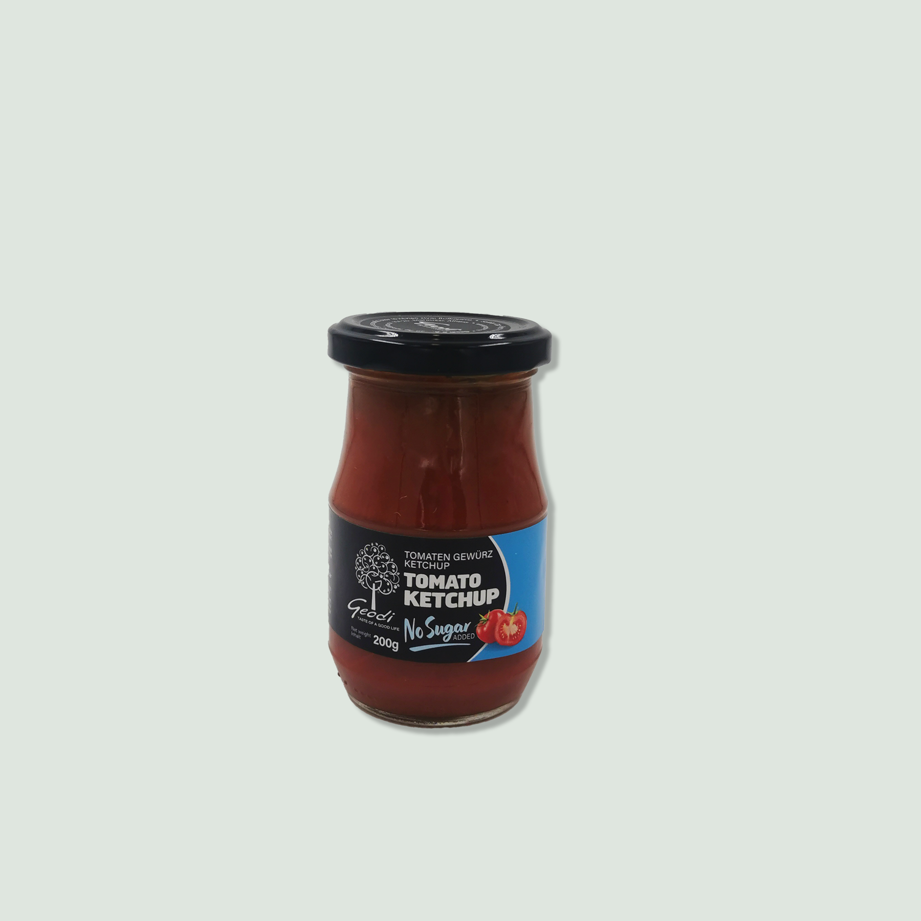 A jar of Geco Tomato Ketchup with no added sugar. The jar has a black lid and a blue and black label featuring a tomato illustration and text indicating the product name and ingredients.