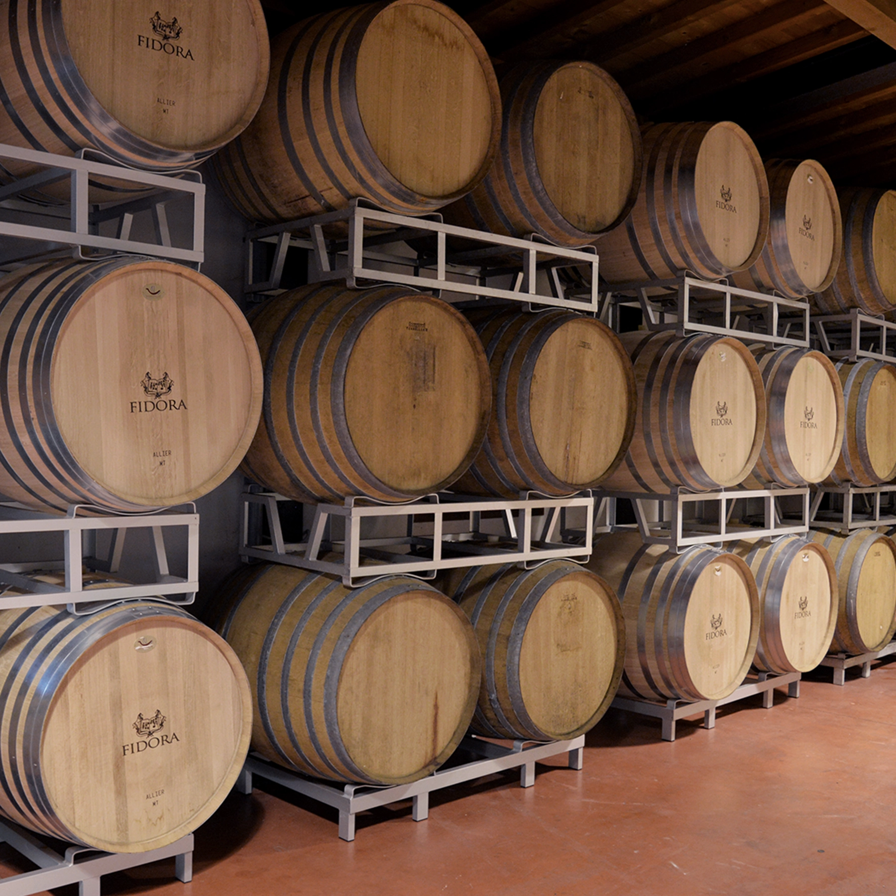 Traditional oak barrels used for aging Valpolicella DOC Italian wine at Fidora’s organic winery.