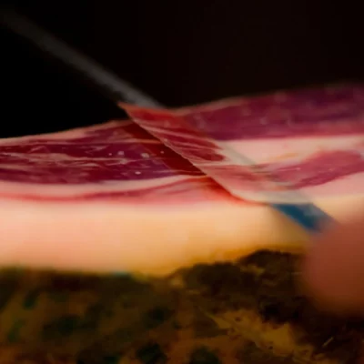 Sliced Jamón Gran Reserva on a wooden board highlighting its tender, cured meat slices