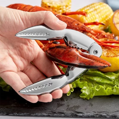 Premium seafood cracker placed beside a lobster tail on a wooden serving board